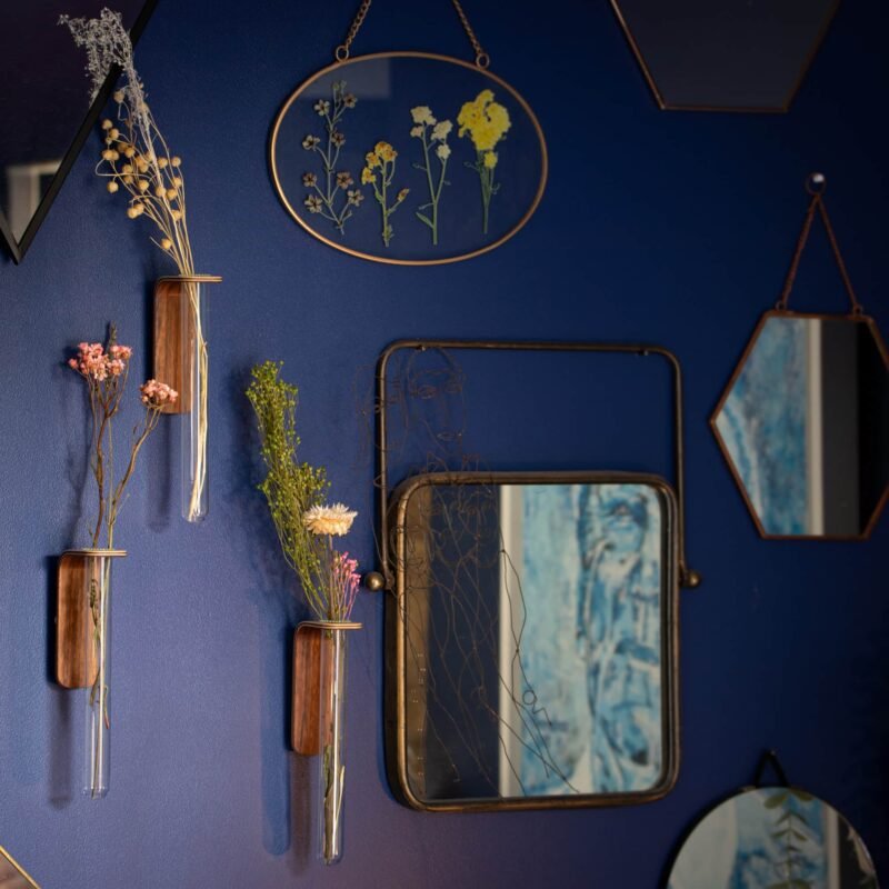 trois soliflore en bois sur un mur bleu